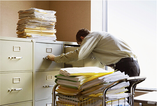 Employee sorting through document filing cabinets