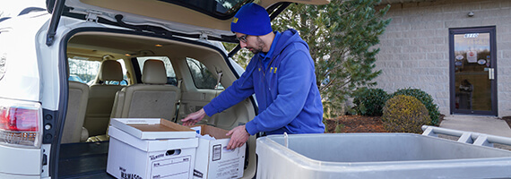 TITAN Mobile Shredding employee off loading drop and go document shredding boxes