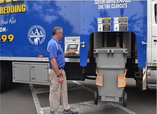 TITAN Mobile Shredding truck driver emptying shred bin onto truck