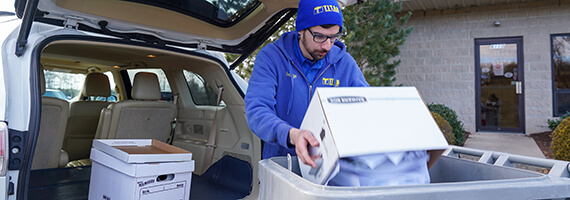 TITAN Mobile Shredding employee off loading drop and go document shredding boxes