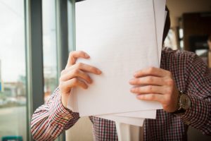 a man holding a pile of papers