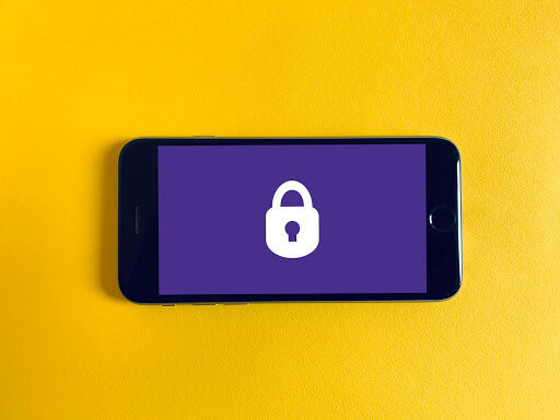 a cell phone against a yellow background with a purple cover