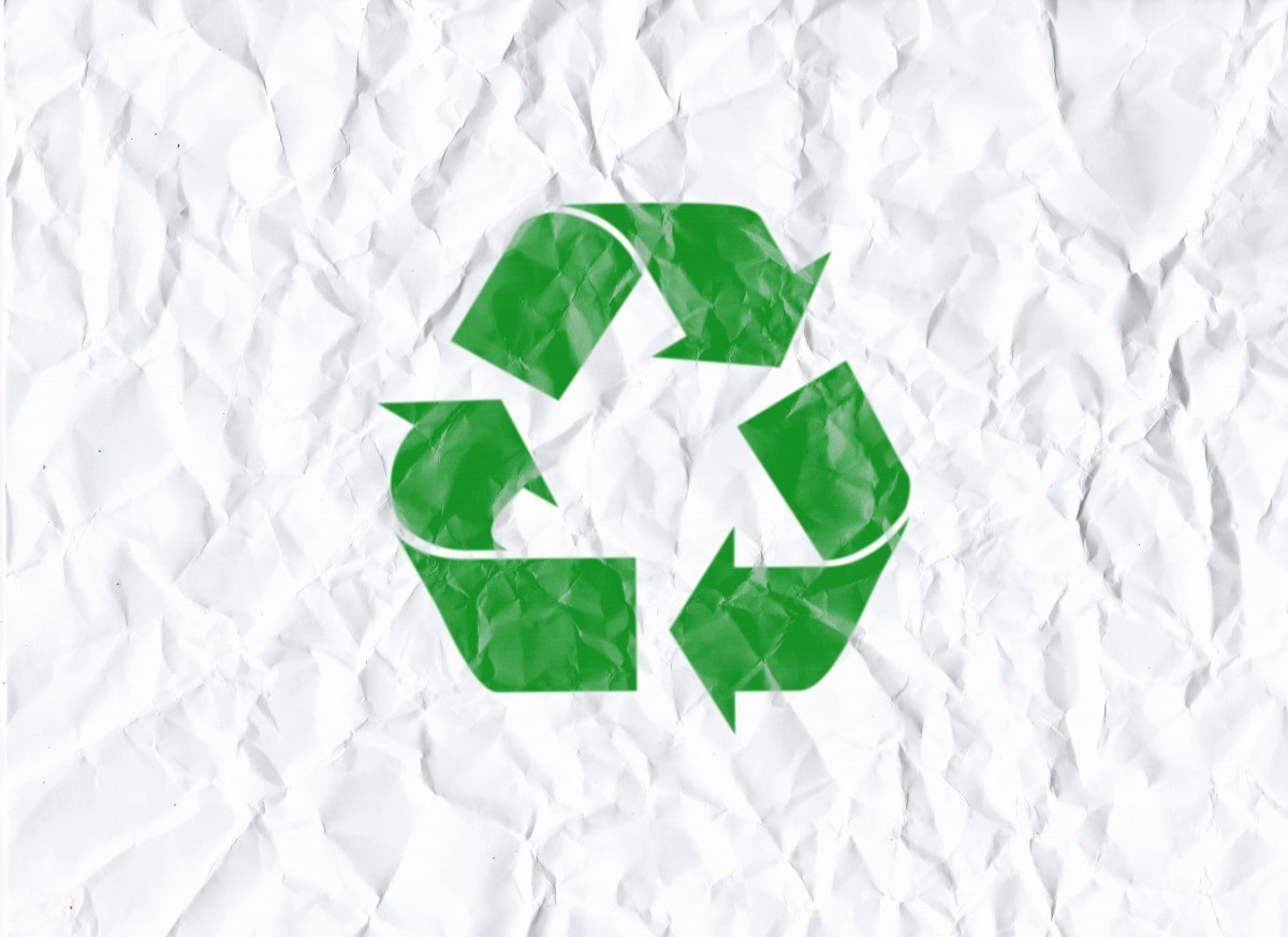 Recycle icon displayed prominently on a textured crumpled paper background, symbolizing sustainability and environmental awareness.