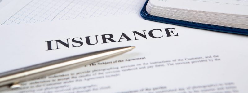 Closeup the silver ballpoint modern pen on insurance contract with planning in background.