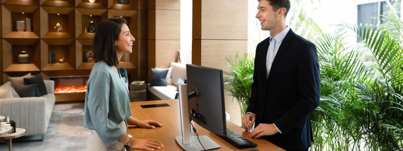a hotel front desk employee helping a customer
